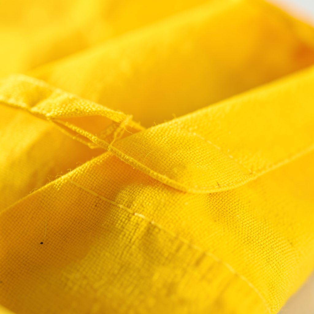 Primer plano de una bolsa de papel con un diseño publicitario impreso en tinta negra sobre la superficie kraft marrón, mostrando la textura rugosa del material