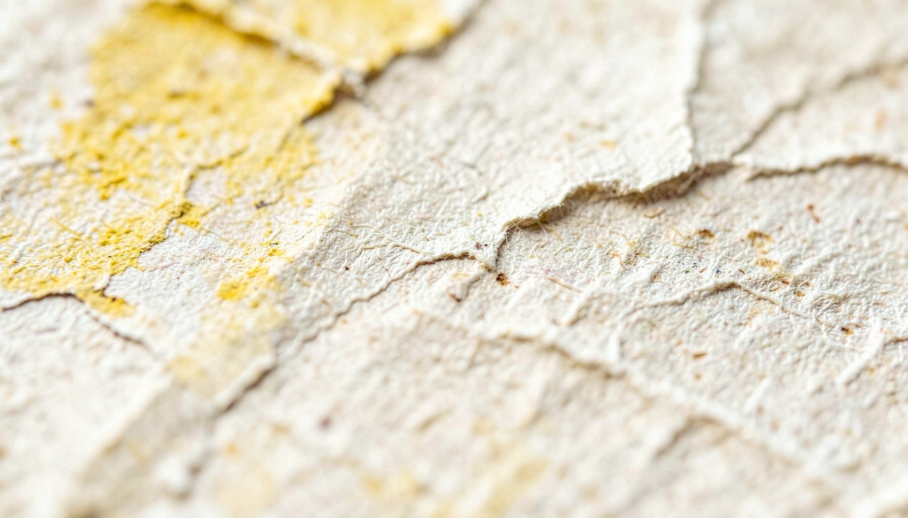 Primer plano extremo de una textura de papel arrugado y desgastado, con tonos crema, beige y sombras suaves que evocan el paso del tiempo y la melancolía.